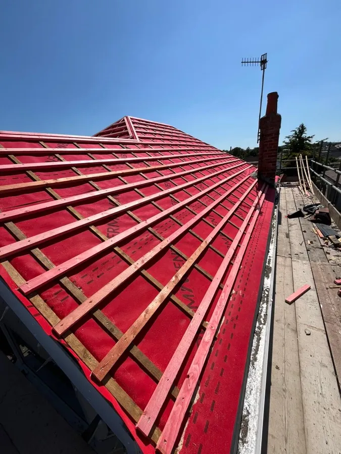 Roof battens and membrane fitted across a hip roof, ready for tiling